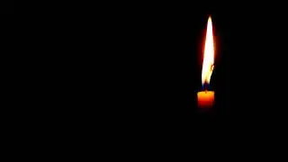 A single candle burning in the dark