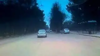 Машина с синими номерами в кармане на остановке.