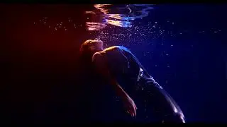 Underwater video shooting. Girl in the pool with neon light