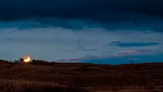 Partial Lunar Eclipse: Moon in partial phase rising to the left of Maunakea