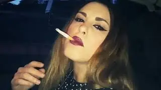 Woman chain smokes in a car