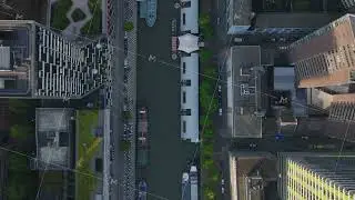 Aerial view of boats on Rotterdam's canal, surrounded by modern high rise buildings in a famous