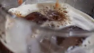 Coffee being poured into a glass with ice