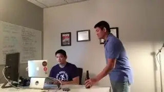Assistant Handing Beer to Web Designer