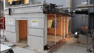 Hydraulic jack applying dynamic horizontal loading on a masonry building