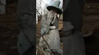 Старый гном сидит  грустный на руинах летнего кафе 