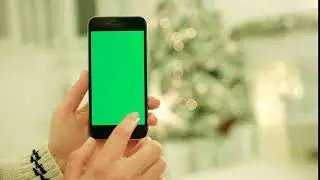 close up of female hands touching green screen on mobile phone chroma