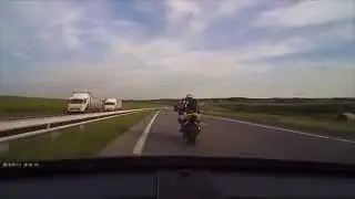 Motorcyclist messes with car, gets hit