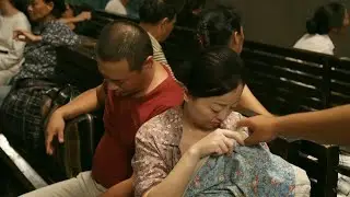 女人正在给小孩喂奶，突然一个陌生男人当众伸手掀开襁褓
