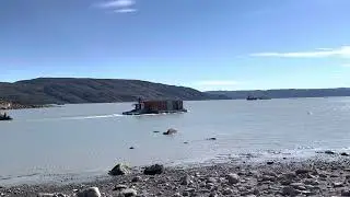 Tugboat and barge taking containers to a waiting ship, Kangerlussuaq harbour, Greenland