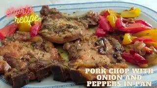 pork chop with onions and peppers in a pan 