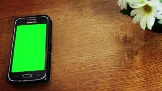 Phone with a green screen on the desk. Video background. Stock footage