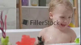 Little girl playing in the bath and splashing water