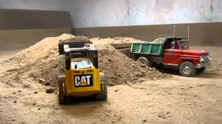 Rubber tracked skid steer loading Tonka Dump Truck