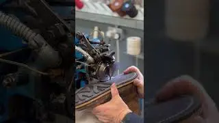 Tricker's craftsman stitching a Ridgeway sole on to a country boot.