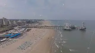 Aerial view of The Hague beach with pier and ferris wheel on a sunny day. Urban landscape and