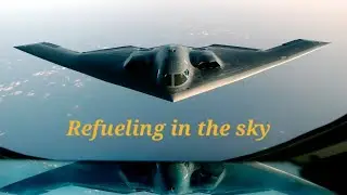 Stealt bomber refuelling in the sky while flying.