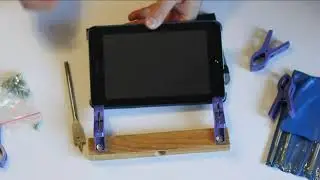 DIY.  tablet holder. Made of a block of wood and two clothespins.