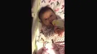 Zealyn Skye trying to hold her medela bottle at 4 months old