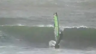Windsurfers sail waves while a band jams  -  at the beach, March 29, 2019
