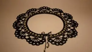 Черный ажурный воротник с золотистыми бусинами.