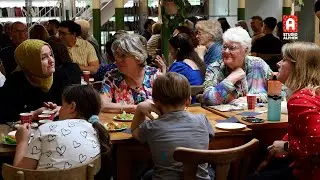 Samenkomen met hapjes en drankjes bij Dag van de Vluchteling in Buurthuis Mozaïek