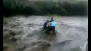People are swept over a waterfall