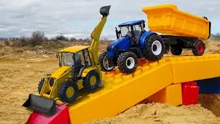 Leo builds a bridge out of blocks, cars, an excavator, a truck and a JCB tractor help