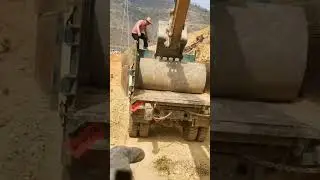 Excavator unloading concrete water pipe