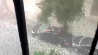 Мужчина пытается спасти свой автомобиль от града
