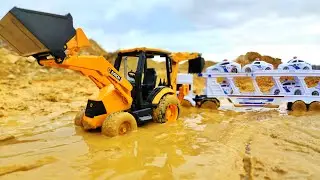 History of toy cars. Tractor helped a stuck car transporter get out of the mud