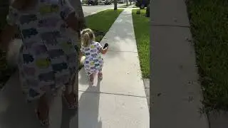 Маленькая девочка выгуливает собаку на тротуаре. Милое видео! 