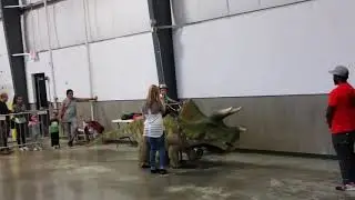 Nicholas riding a triceratops at Jurassic Quest