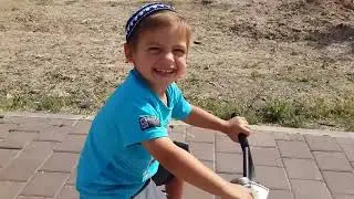 אריה יהודה רוכב על אפניים עם גלגלי עזר. 2014.