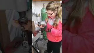 Daughter Zoe using a planisher on copper moonshine still parts