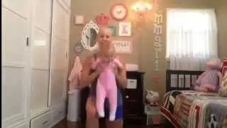 Молодая мама занимаетса спортом.с ребёнкам на руках