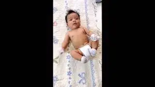 Cute baby boy trying to turn over.
