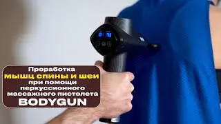 Work your back and neck muscles with the BODYGUN percussion massage gun