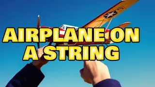 He's Flying the plane with a string. (CONTROL LINE)