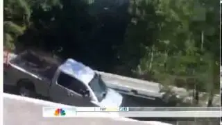 Truck crashes through guardrail; driver will recover.