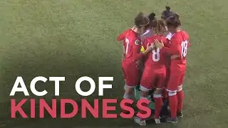 Opponents huddle around soccer player after hijab comes loose during match