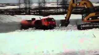 Экскаватор тянет КамАЗ через реку