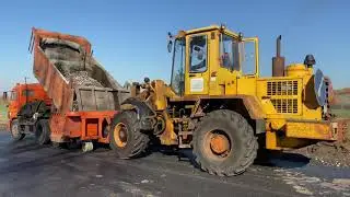 Автогрейдер и щебнеукладчик на укреплении обочины.