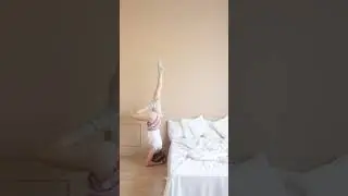 cute girl doing headstand & leg stretch exercise in her bedroom.