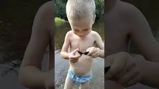 Рома ищет ракушки на речке)