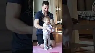 Toddler Girl Does Stretching Exercises at Home With Dad's Help