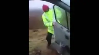 Шотландец пытается закрыть дверь автомобиля во время штормового ветра