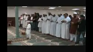 Маленький мальчик в намазе читает Коран..