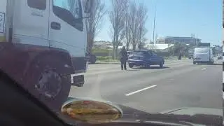 Only in Africa. Guy replaces flat tire in middle lane on busy Highway in Cape Town