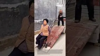 Pulling wife on wheeled chair up ramp: elderly man pulling his wife on a wheeled chair up a ramp